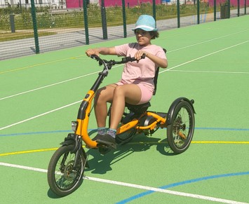 Teenage girl riding an inclusive cycle